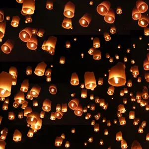 The image is a photograph of a dark sky filled with warmly lit paper lanterns. The lanterns have many meanings including hope in the dark and honoring ancestors.