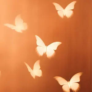 White butterflies on an ombre orange background.