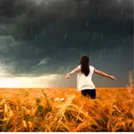 A woman standing in a field of ripe wheat. Her arms are open wide as a dark storm approaches. The wind can be felt in the wheat, in the clothes and hair. The storm is approaching and swirling around her.