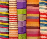 A photographic image of various colorful and striped fabrics.