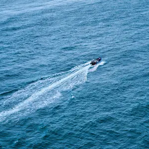 An image of a boat zooming across deep blue fast moving water.