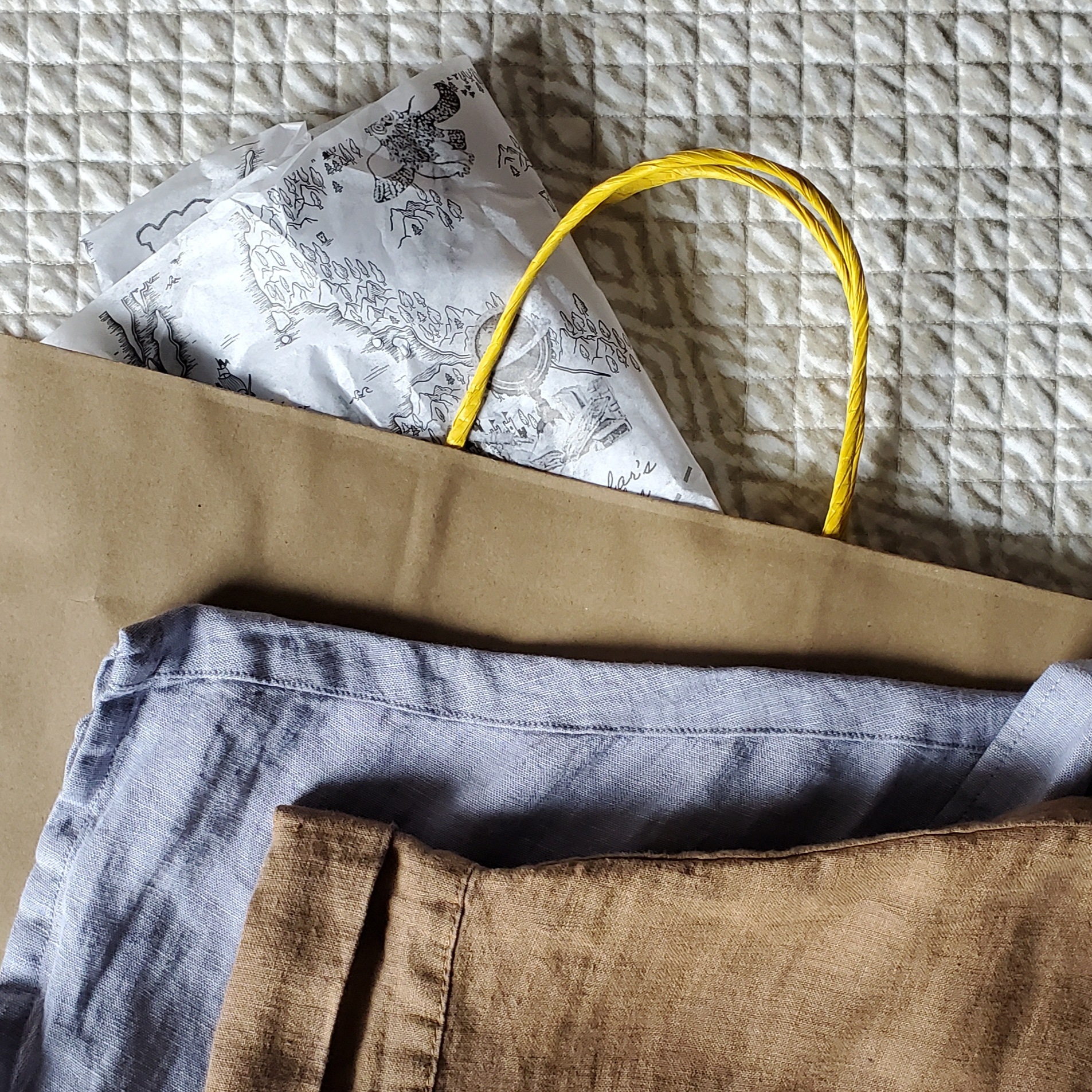 A brown paper shopping bag and clothing.