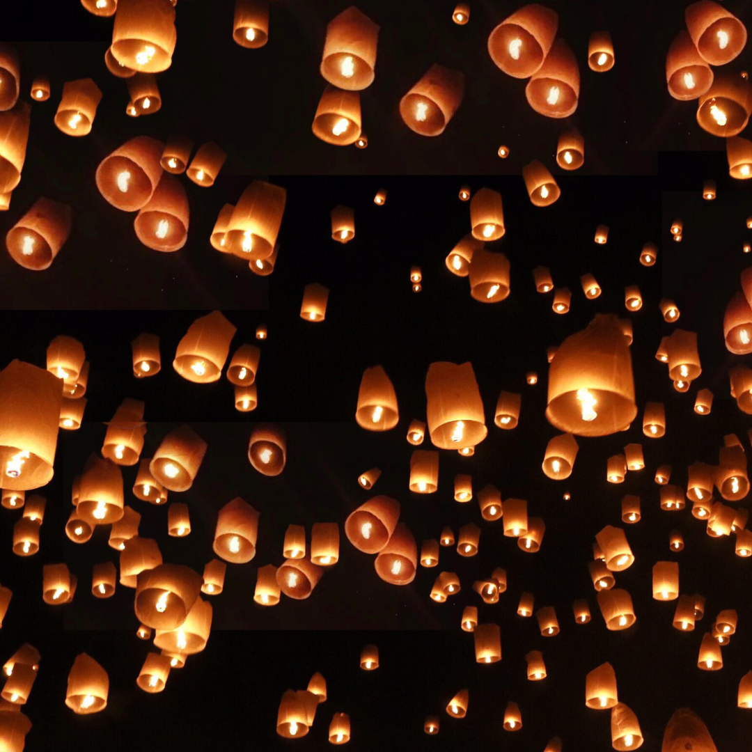 The image is a photograph of a dark sky filled with warmly lit paper lanterns. The lanterns have many meanings including hope in the dark and honoring ancestors. The image is a photograph of a dark sky filled with warmly lit paper lanterns. The lanterns have many meanings including hope in the dark and honoring ancestors.