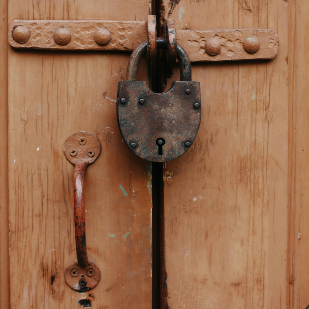 An image of a vintage padlock on a closed gate. An image of a vintage padlock on a closed gate.