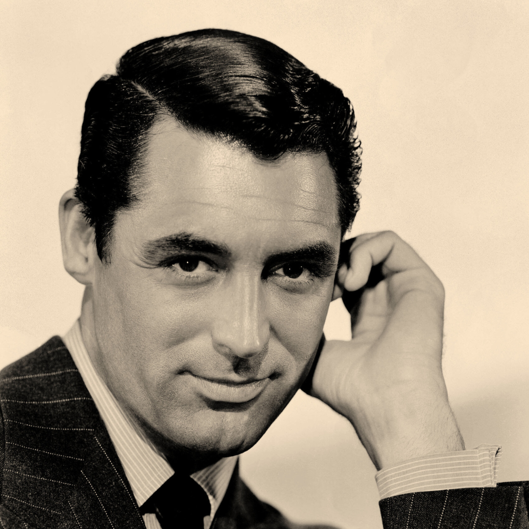 A publicity headshot of Cary Grant in shades of black, grey, and yellow. Grant in looking at the viewer with piercing dark eyes and a slight smile. His left had is near is left ear giving the image a casual feel, but his suit says he is all business. A publicity headshot of Cary Grant in shades of black, grey, and yellow. Grant in looking at the viewer with piercing dark eyes and a slight smile. His left had is near is left ear giving the image a casual feel, but his suit says he is all business.
