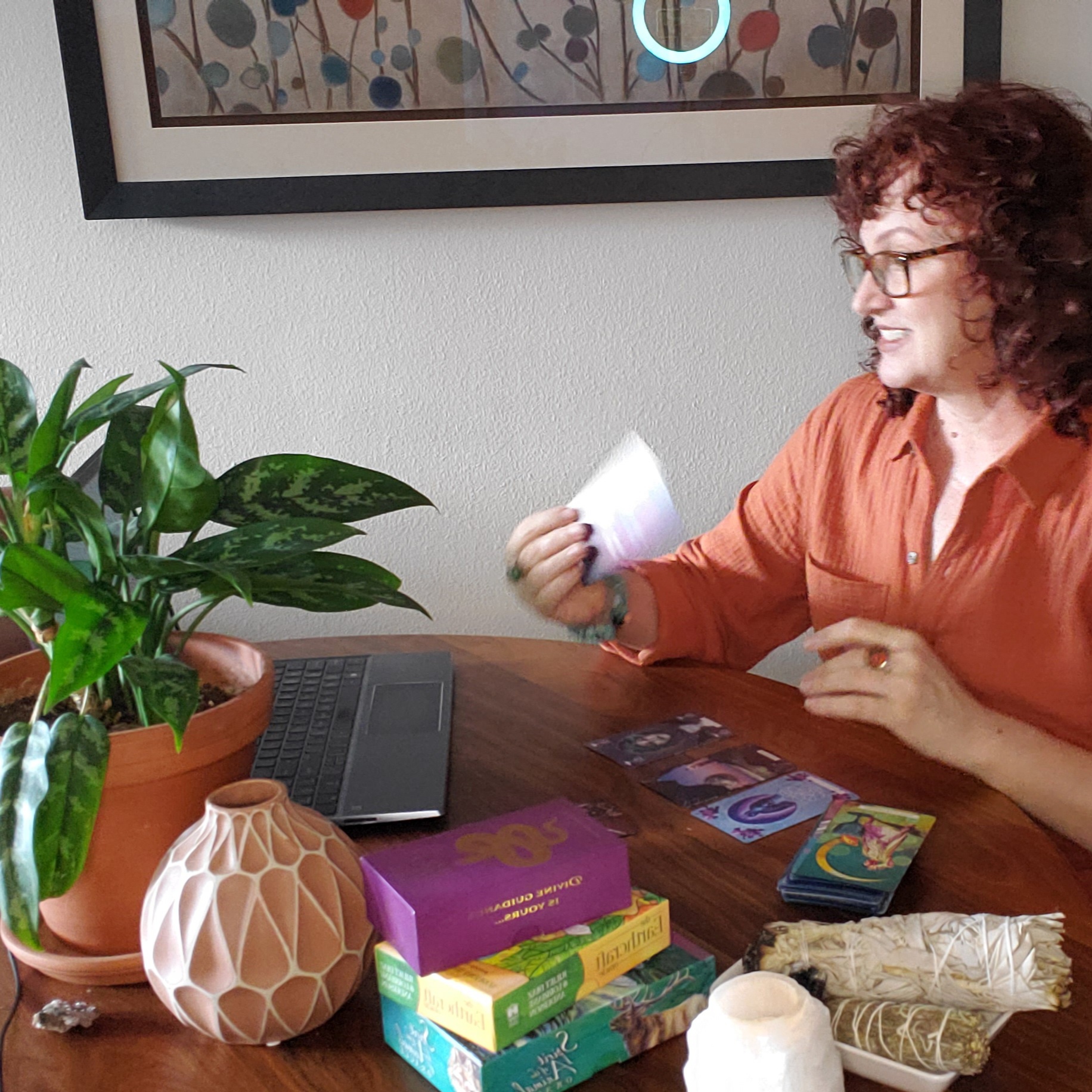 A picture of me with tarot cards in consultation at my kitchen table. One of my favorite places to work.