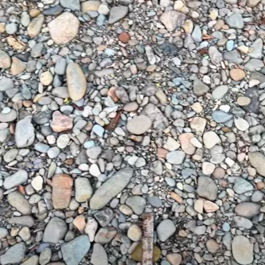 A dry riverbed filled with smooth river stones.