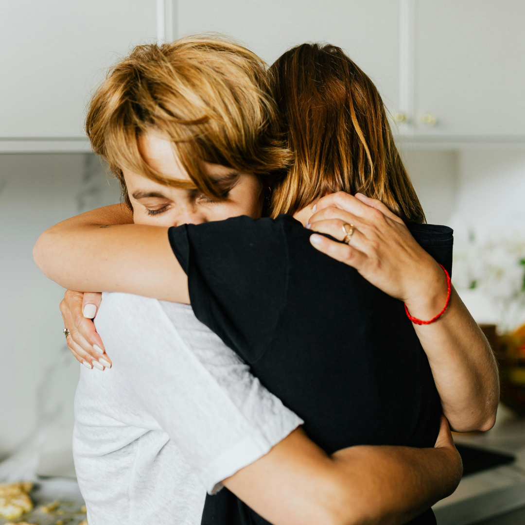 An image of two women hugging closely.