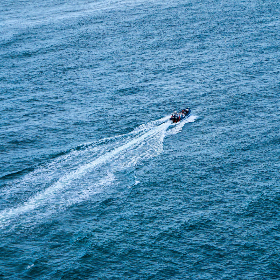 An image of a boat zooming across deep blue fast moving water.